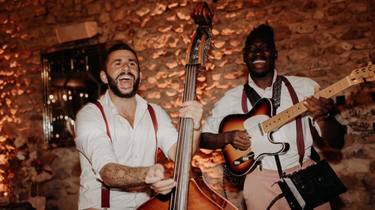 deux musiciens du groupe Les Garçons Chics jouant leurs instruments et chantant dans une ambiance tamisée