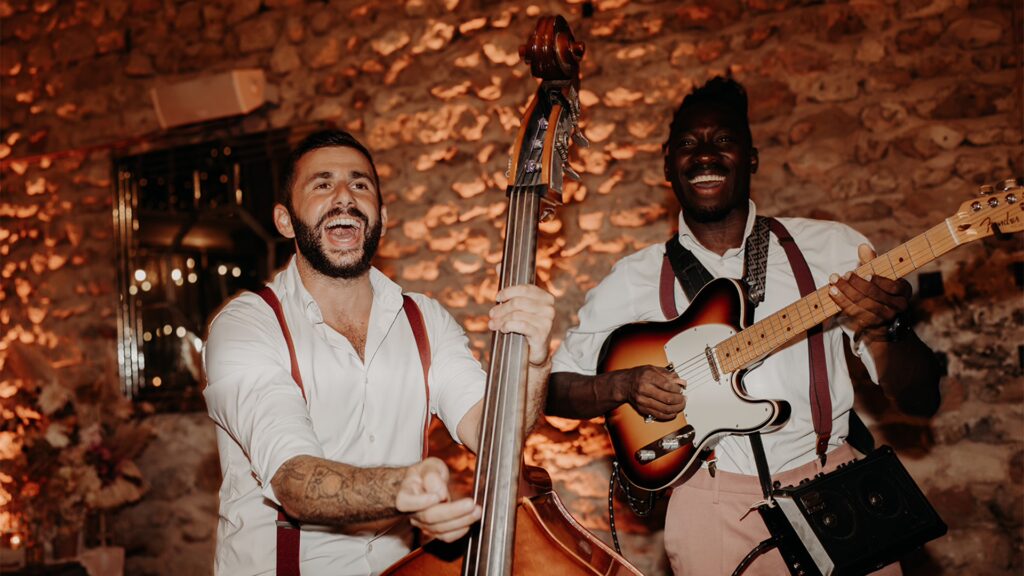 deux musiciens du groupe Les Garçons Chics jouant leurs instruments et chantant dans une ambiance tamisée