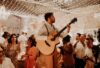 guitaristes du groupe Les Garçons Chics jouant leurs instruments et chantant au milieu de convives